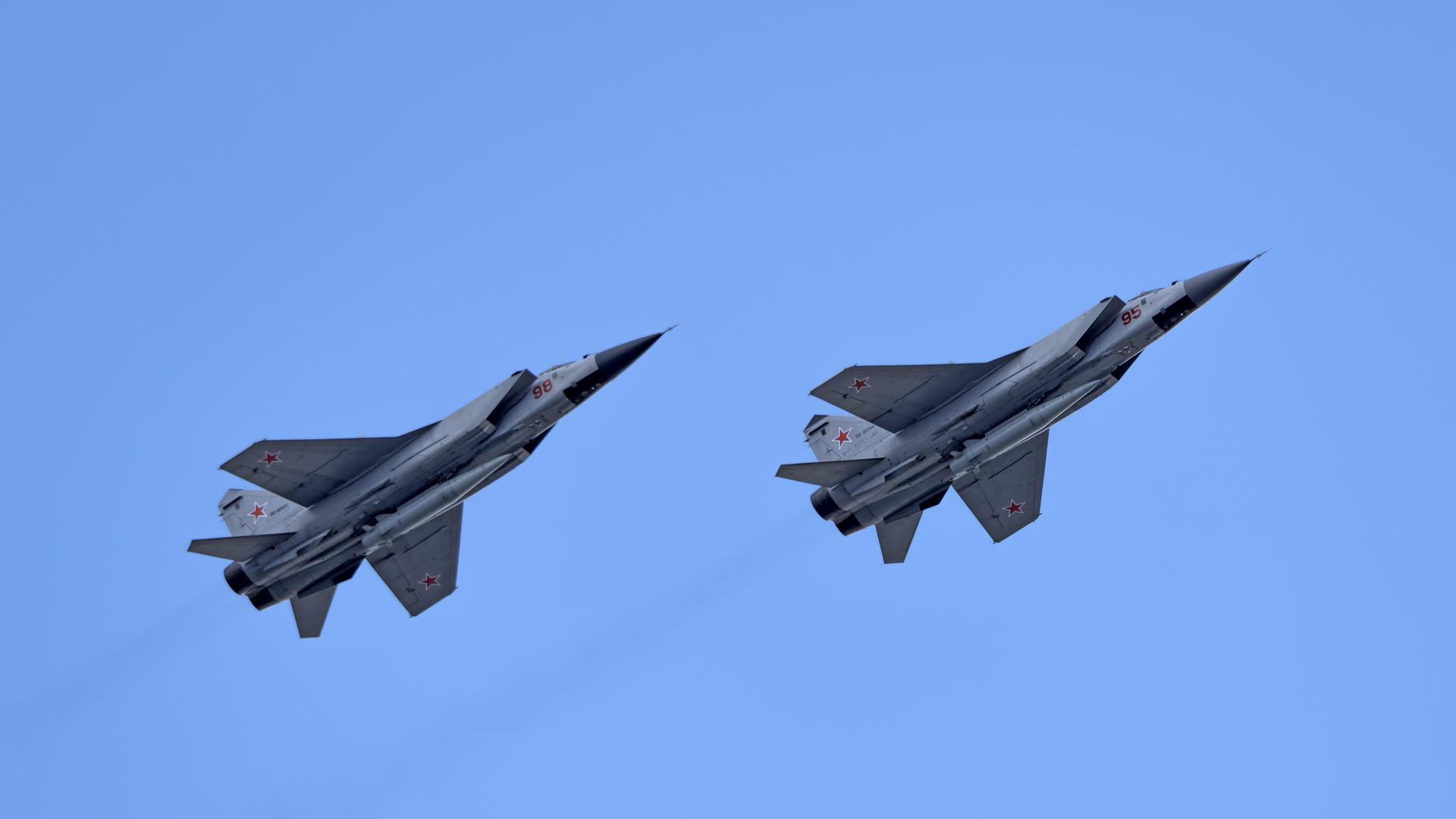 Die beiden Düsenjäger fliegen nebeneinader im wolkenlosen blauen Himmel. 