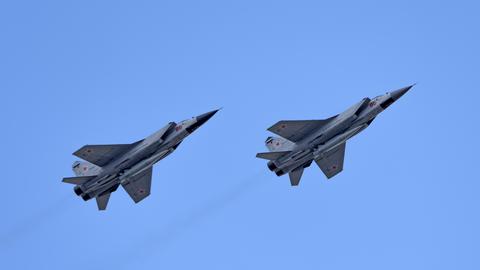 Die beiden Düsenjäger fliegen nebeneinader im wolkenlosen blauen Himmel. 