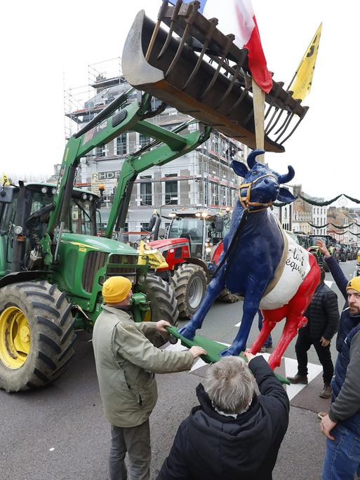 Französische Landwirte protestieren auf der Straße gegen das Mercosur-Freihandelsabkommen. Sie führen eine Kuh-Skulptur mit sich, die in den Farben der französischen Nationalflagge gehalten ist. Französische Landwirte protestieren auf der Straße gegen das Mercosur-Freihandelsabkommen. Sie führen eine Kuh-Skulptur mit sich, die in den Farben der französischen Nationalflagge gehalten ist.