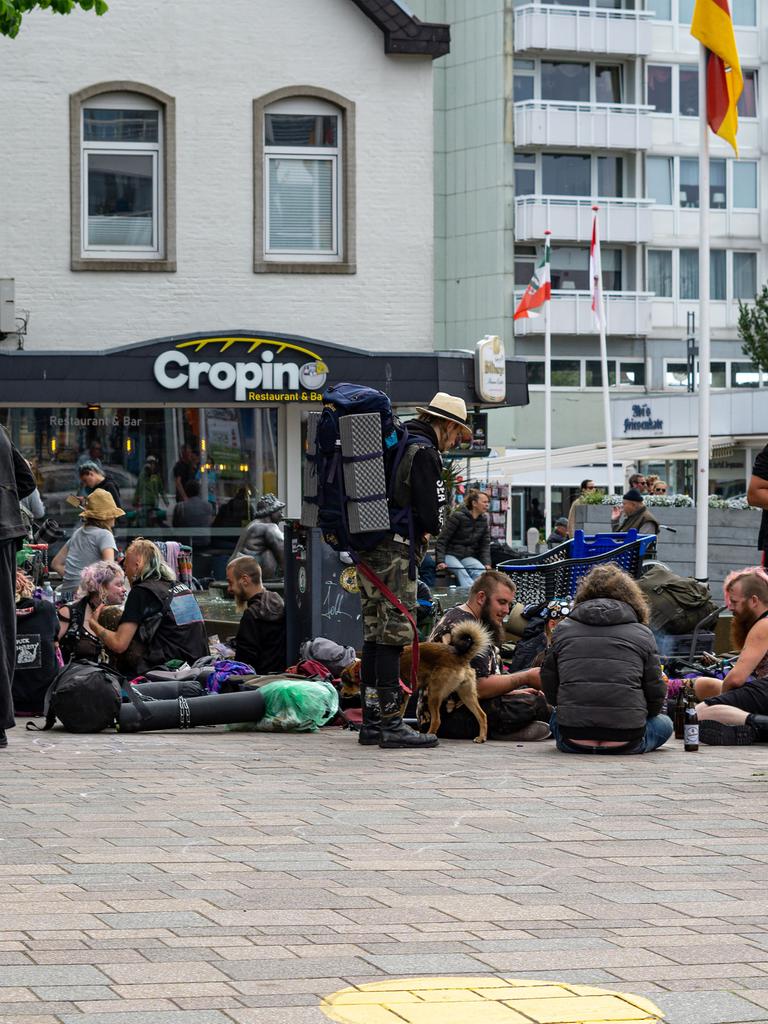 In der Innenstadt von Westerland auf Sylt sitzen viele Punks. Sie haben Rücksäcke und Hunde bei sich.