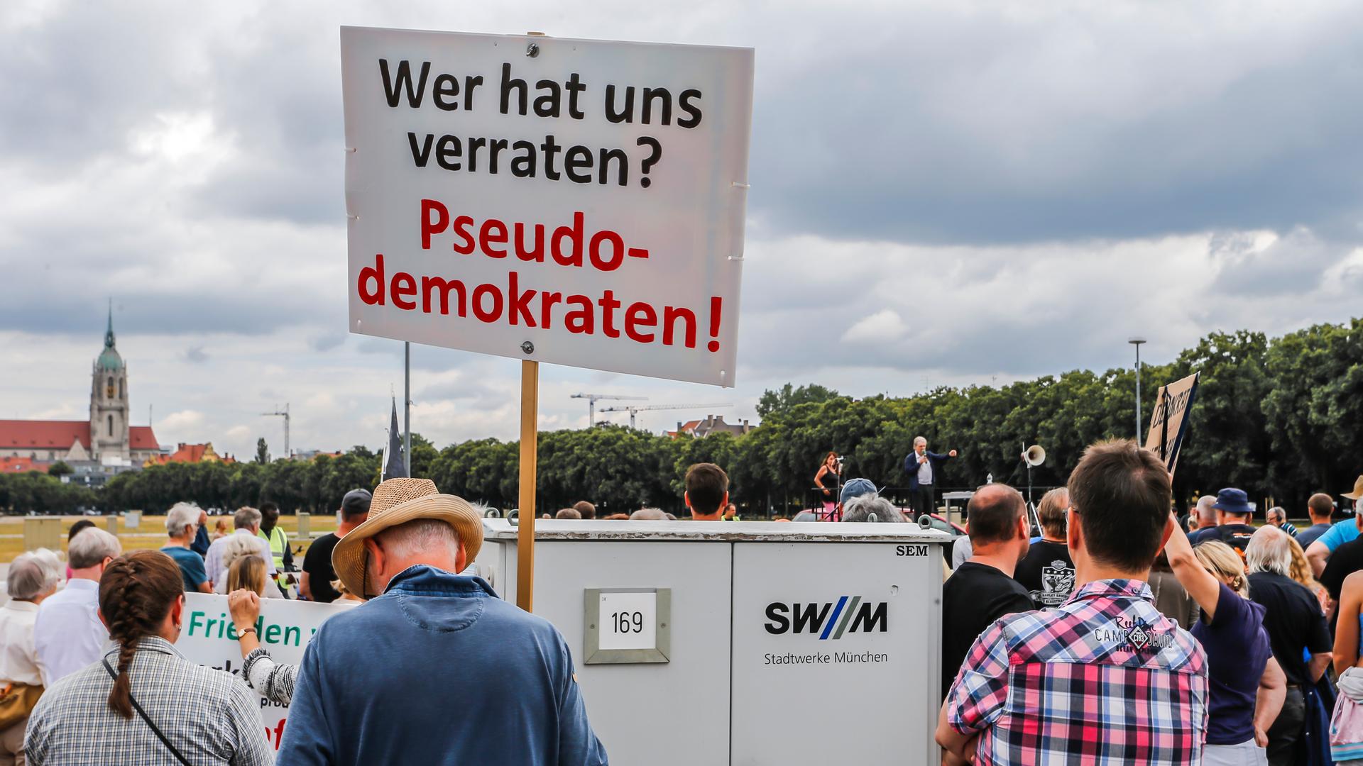 Zu sehen sind mehrere Teilnehmer einer Demonstration gegen das Heizungsgesetz, einer von ihnen hält ein Plakat mit der Aufschrift "Wer hat uns verraten? - Pseudodemokraten!" in die Höhe. 