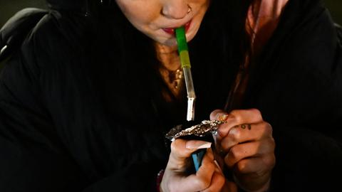 Nahaufnahme einer jungen Frau, die Fentanyl raucht.