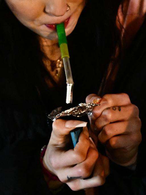 Nahaufnahme einer jungen Frau, die Fentanyl raucht.