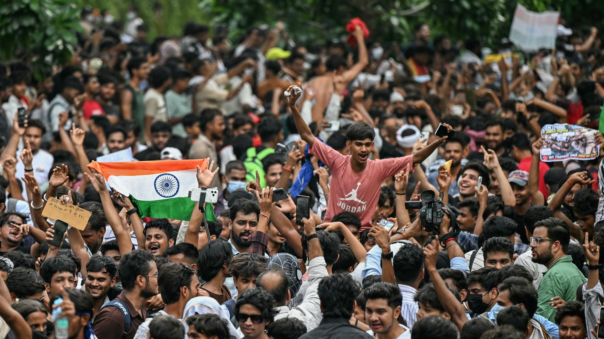 Junge Menschen bei einer Demonstration. Einige schwenken indische Flaggen in rot, weiß und grün. Junge Menschen bei einer Demonstration. Einige schwenken indische Flaggen in rot, weiß und grün.