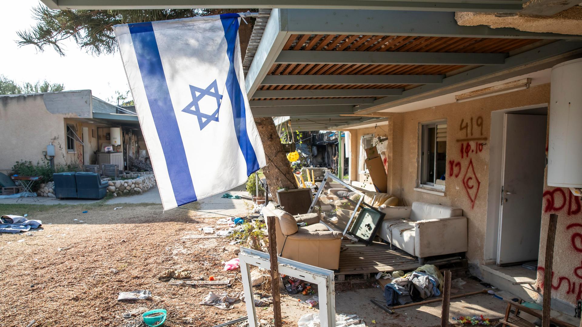 Der weitgehend zerstörte Kibbuz Kfar Aza und eine einsame Israel-Fahne. 