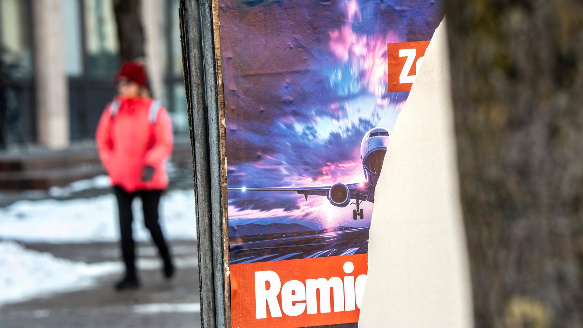 Ein Wahlplakat der AfD ist teilweise abgerissen. Darauf war die Forderung nach "Remigration" geschrieben sowie ein Flugzeug abgebildet.