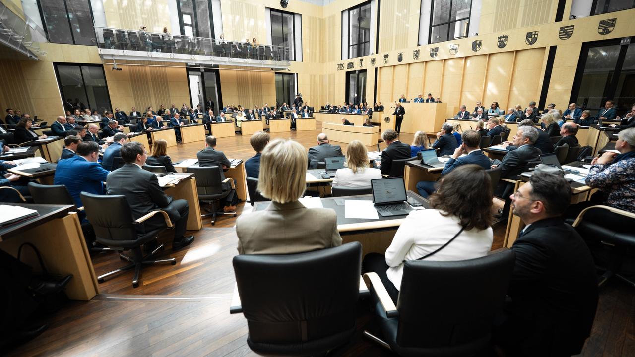 Blick in den Plenarsaal des Bundesrats. Man sieht mehrere Stühle auf denen Menschen sitzen. 