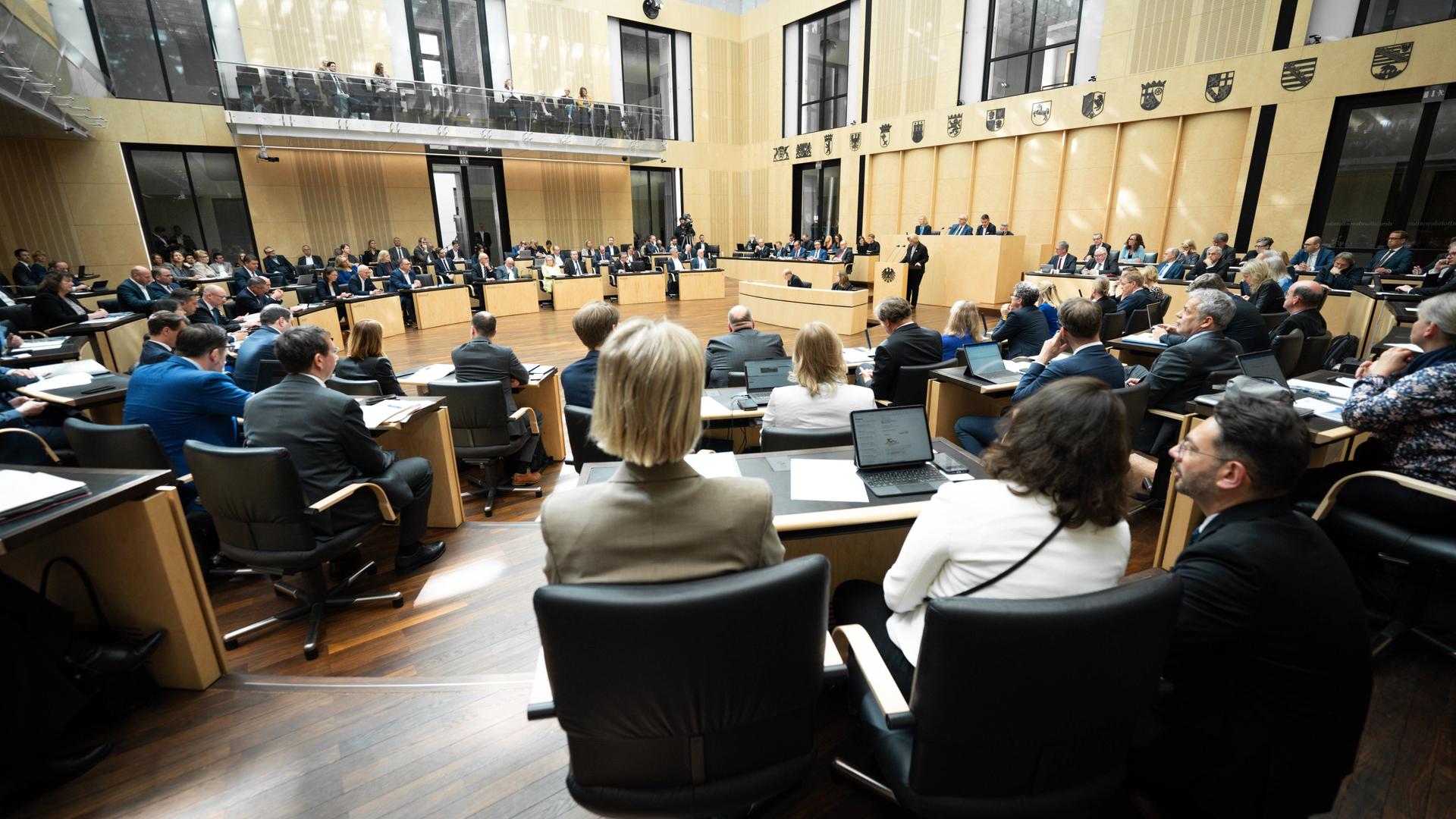Blick in den Plenarsaal des Bundesrats. Man sieht mehrere Stühle auf denen Menschen sitzen. Blick in den Plenarsaal des Bundesrats. Man sieht mehrere Stühle auf denen Menschen sitzen.