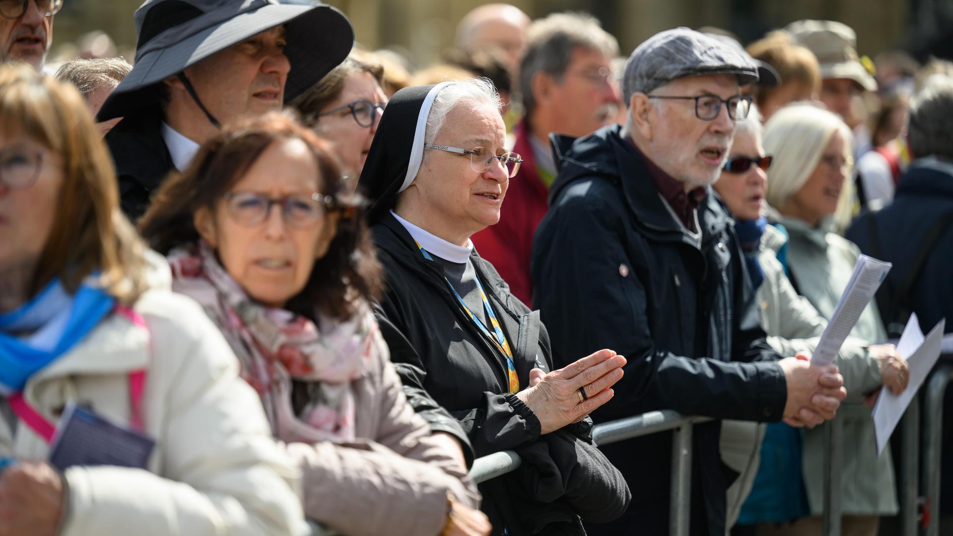 Menschen stehen während einer christlichen Veranstaltung unter freiem Himmel. Menschen stehen während einer christlichen Veranstaltung unter freiem Himmel.
