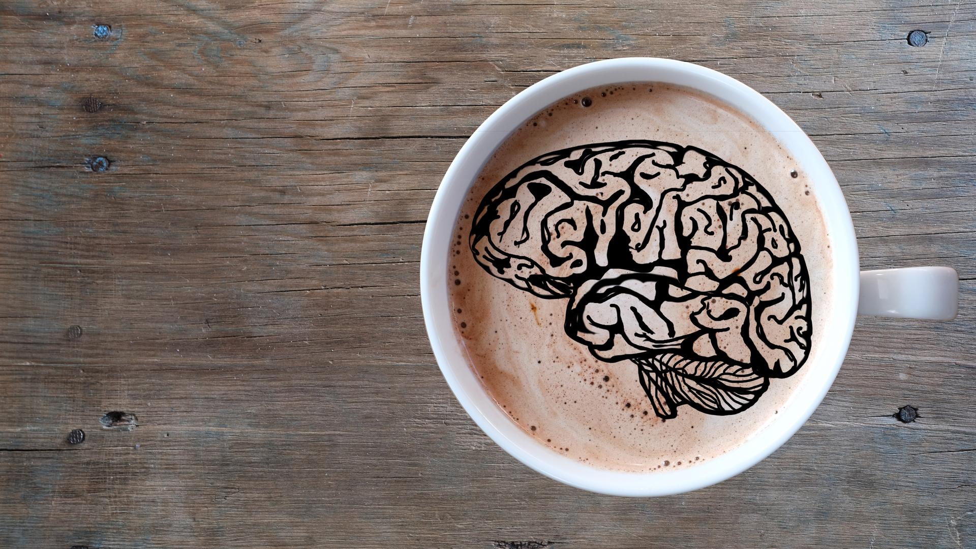 Eine Tasse Kaffee mit dem Muster eines Gehirns auf dem Schaum.