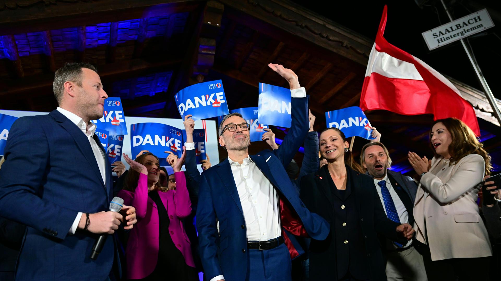 Die Politiker der rechtspopulistischen FPÖ Michael Schnedlitz, Herbert Kickl und Susanne Fürst feiern mit erhobenen Händen und Österreich-Flaggen im Hintergrund ihren Wahlerfolg bei der Nationalratswahl in Wien. 