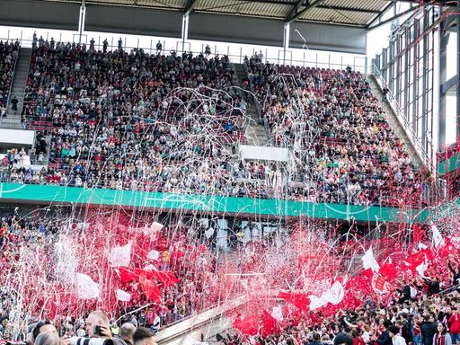 Die Fans des SC Freiburg lassen zu Beginn des Pakalfinals in Köln Konfetti fliegen und wedeln mit Fahnen.