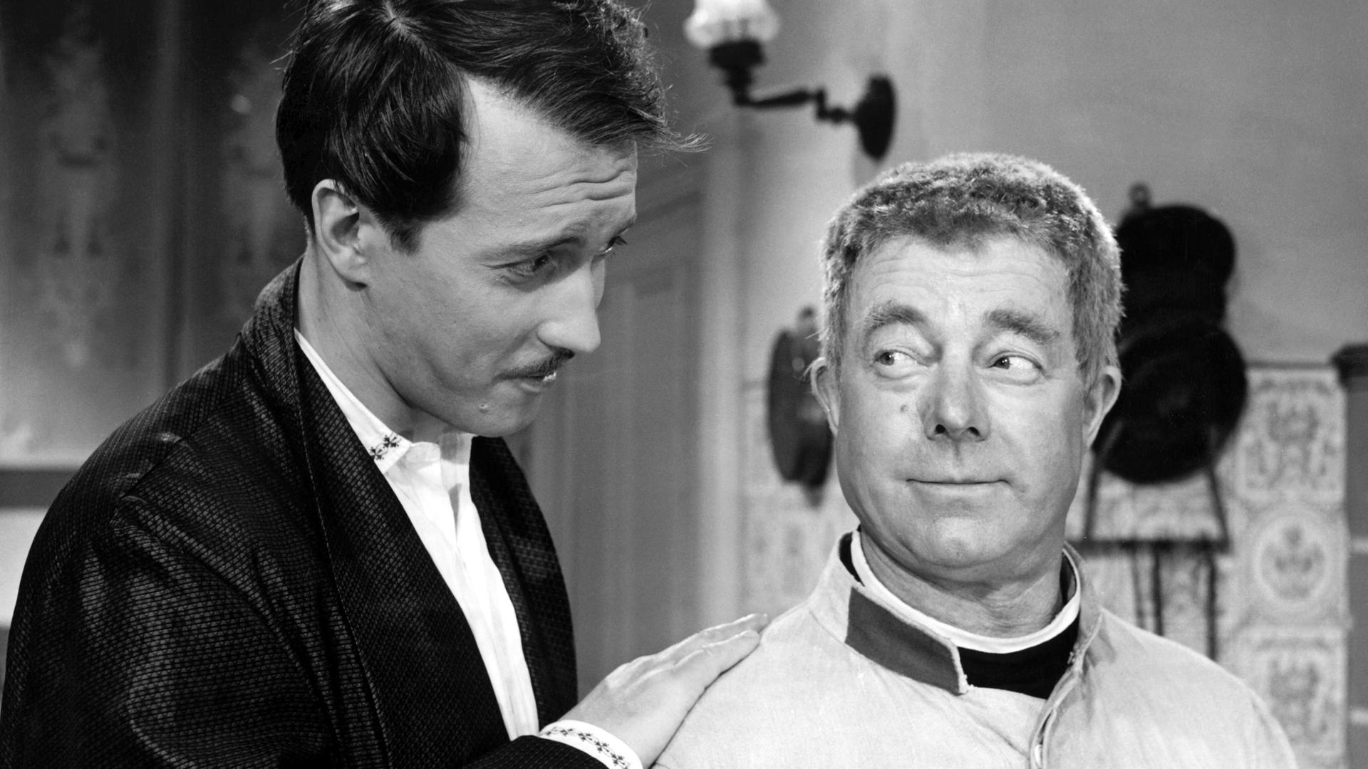 Der deutsche Schauspieler Heinz Rühmann als Soldat Schwejk mit seinem Vorgesetzten und Freund Oberleutnant Lukas. Das Foto zeigt die beiden Schauspieler in Schwarz-Weiß. Es handelt sich um eine Szene aus dem Film von 1960. Der deutsche Schauspieler Heinz Rühmann als Soldat Schwejk mit seinem Vorgesetzten und Freund Oberleutnant Lukas. Das Foto zeigt die beiden Schauspieler in Schwarz-Weiß. Es handelt sich um eine Szene aus dem Film von 1960.