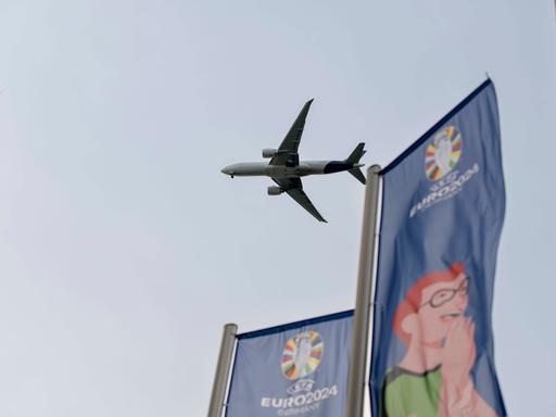 Ein Flugzeug im Landeanflug auf den Frankfurter Flughafen, vorne wehen EURO-2024-Flaggen.