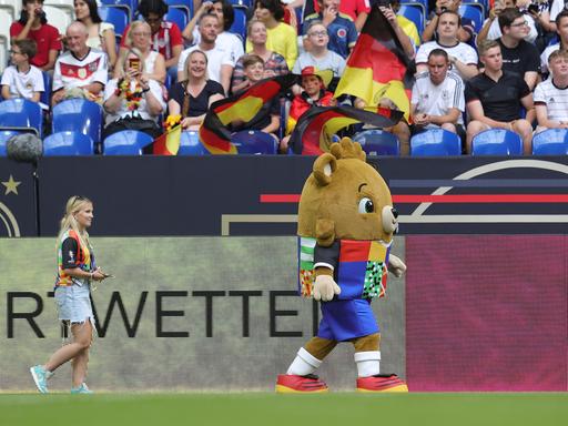 Das Maskotten der EM 2024 spaziert über den Rasen der Arena auf Schalke in Gelsenkirchen. 