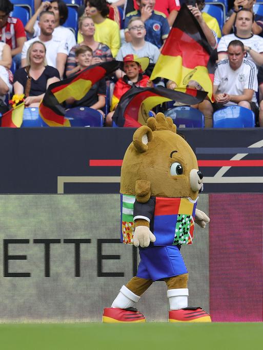 Das Maskotten der EM 2024 spaziert über den Rasen der Arena auf Schalke in Gelsenkirchen. 