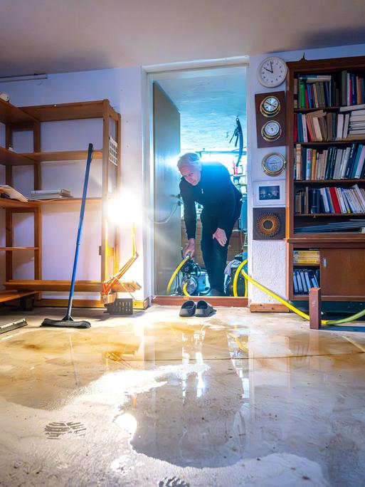 Hausbesitzer Karl Tischer trägt eine Pumpe in den Keller seines Hauses im Bremer Stadtteil Borgfeld, das durch die Hochwasserlage beschädigt wurde.