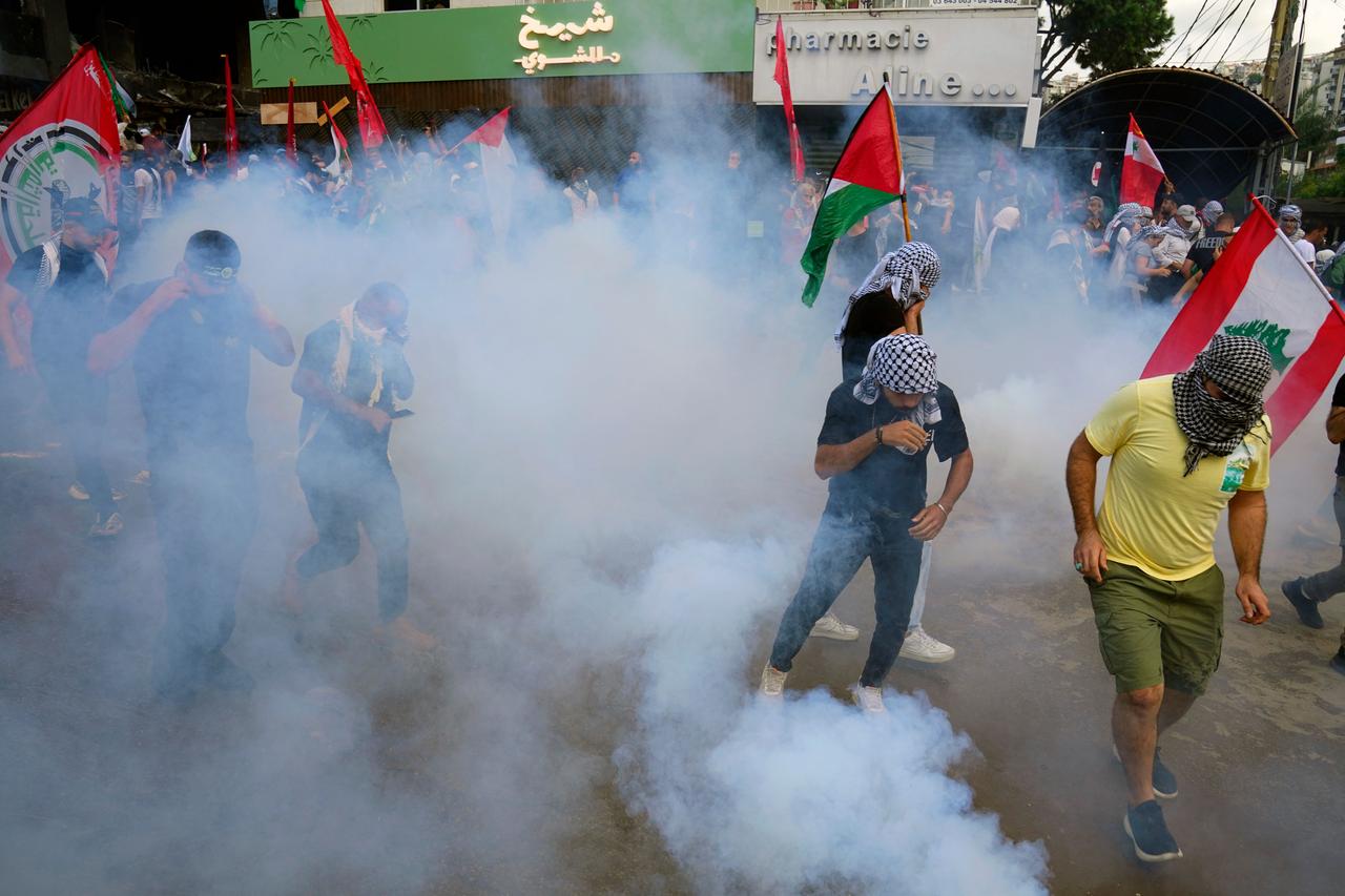 Demonstranten gehen vor Tränengas in Deckung, das von Polizisten während einer Solidaritätsdemonstration mit den Palästinensern im Gazastreifen in der Nähe der US-Botschaft abgefeuert wird.