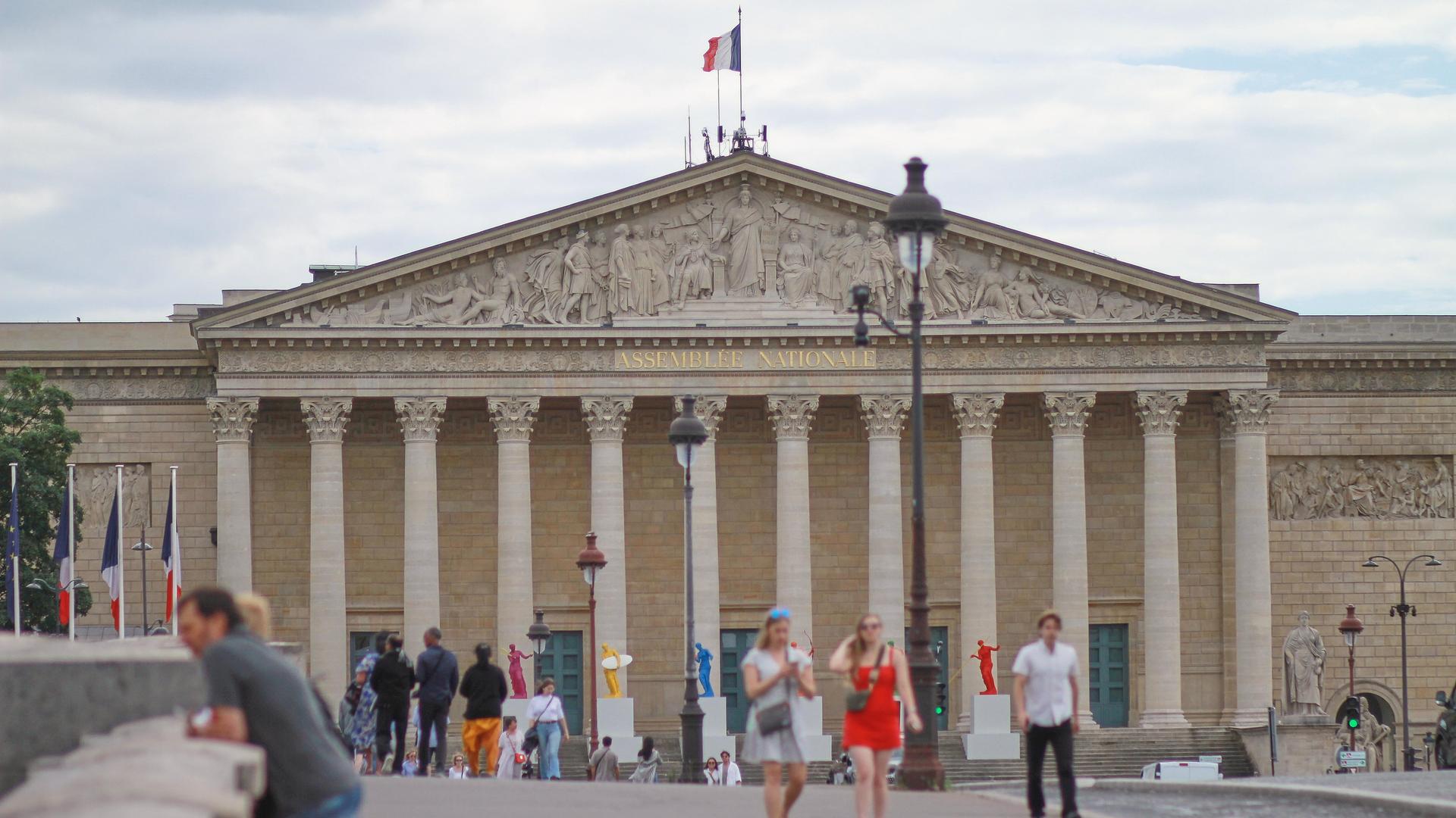 Der Palais Bourbon, der Sitz der französischen Nationalversammlung, mit Touristen davor.
