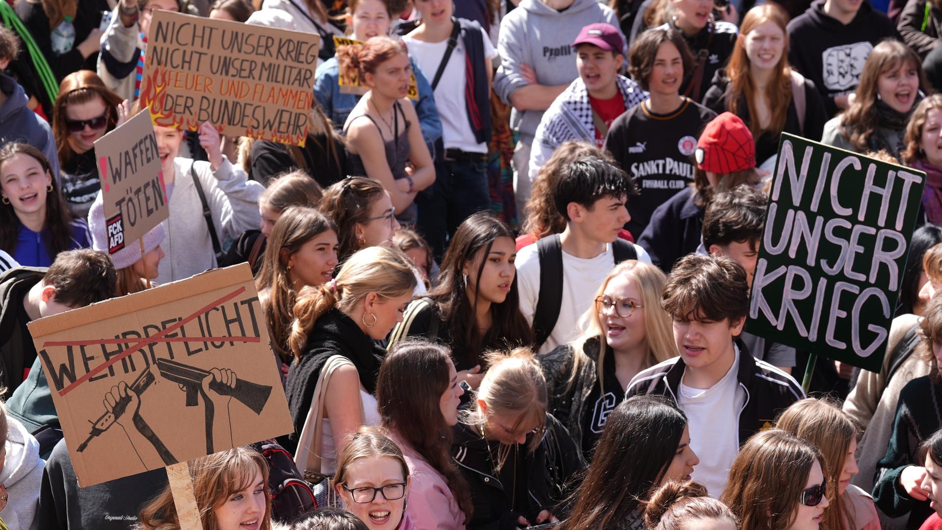 Teilnehmerinnen und Teilnehmer einer Demo halten in der Hamburger Innenstadt Transparente und Plakate hoch. Darauf zu lesen ist zum Beispiel "Nicht unser Krieg" und "Waffen töten". Teilnehmerinnen und Teilnehmer einer Demo halten in der Hamburger Innenstadt Transparente und Plakate hoch. Darauf zu lesen ist zum Beispiel "Nicht unser Krieg" und "Waffen töten".