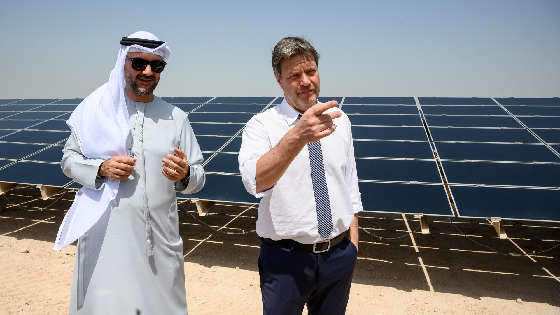 Robert Habeck (Bündnis 90/Die Grünen), Bundesminister für Wirtschaft und Klimaschutz, und Mohamed Jameel Al Ramahi, CEO der Abu Dhabi Future Energy Company (Masdar), vor einer großflächigen Solaranlage