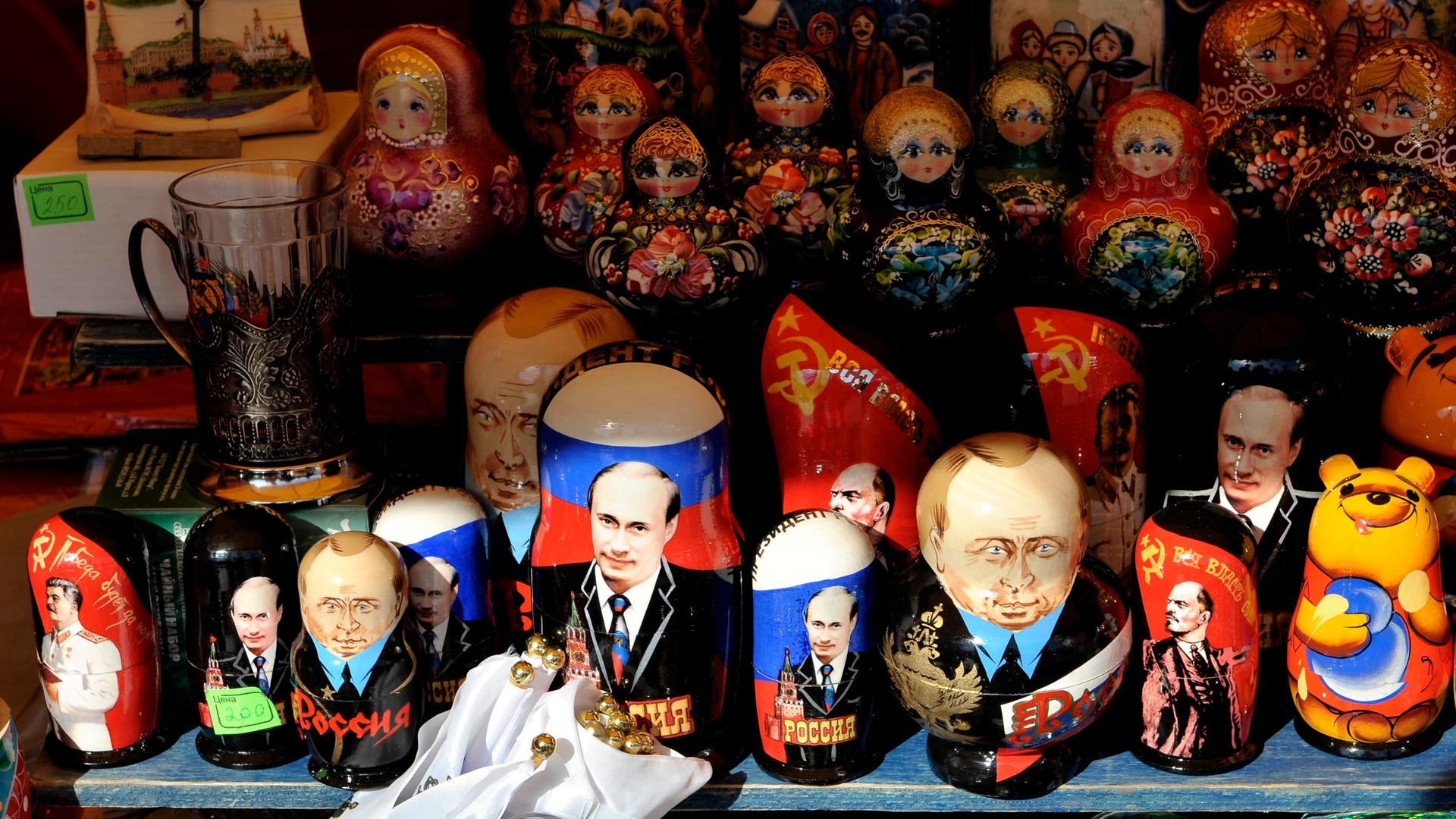 Matrjoschka-Holzpuppen neben Putin-Devotionalien an einem Stand in Moskau