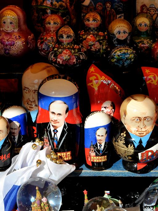 Matrjoschka-Holzpuppen neben Putin-Devotionalien an einem Stand in Moskau Matrjoschka-Holzpuppen neben Putin-Devotionalien an einem Stand in Moskau