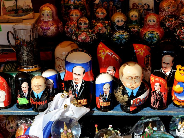 Matrjoschka-Holzpuppen neben Putin-Devotionalien an einem Stand in Moskau Matrjoschka-Holzpuppen neben Putin-Devotionalien an einem Stand in Moskau