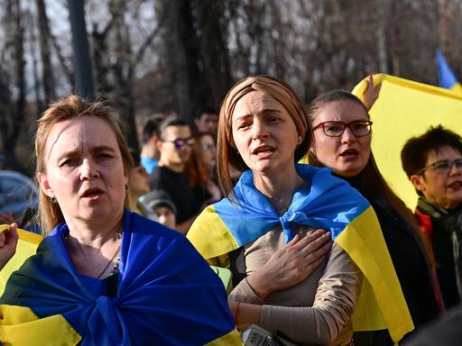Ukrainische Frauen singen während einer Demonstration vor der russischen Botschaft in Bukarest, Rumänien, anlässlich des zweijährigen Krieges seit dem Einmarsch Russlands in die Ukraine.