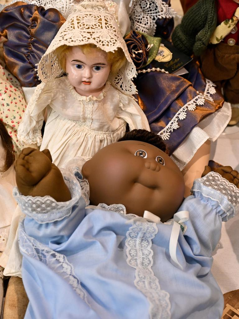 Vier verschiedene Puppen sind auf dem Bild zu sehen, teils mit Porzellangesichtern und feinen Kleidern