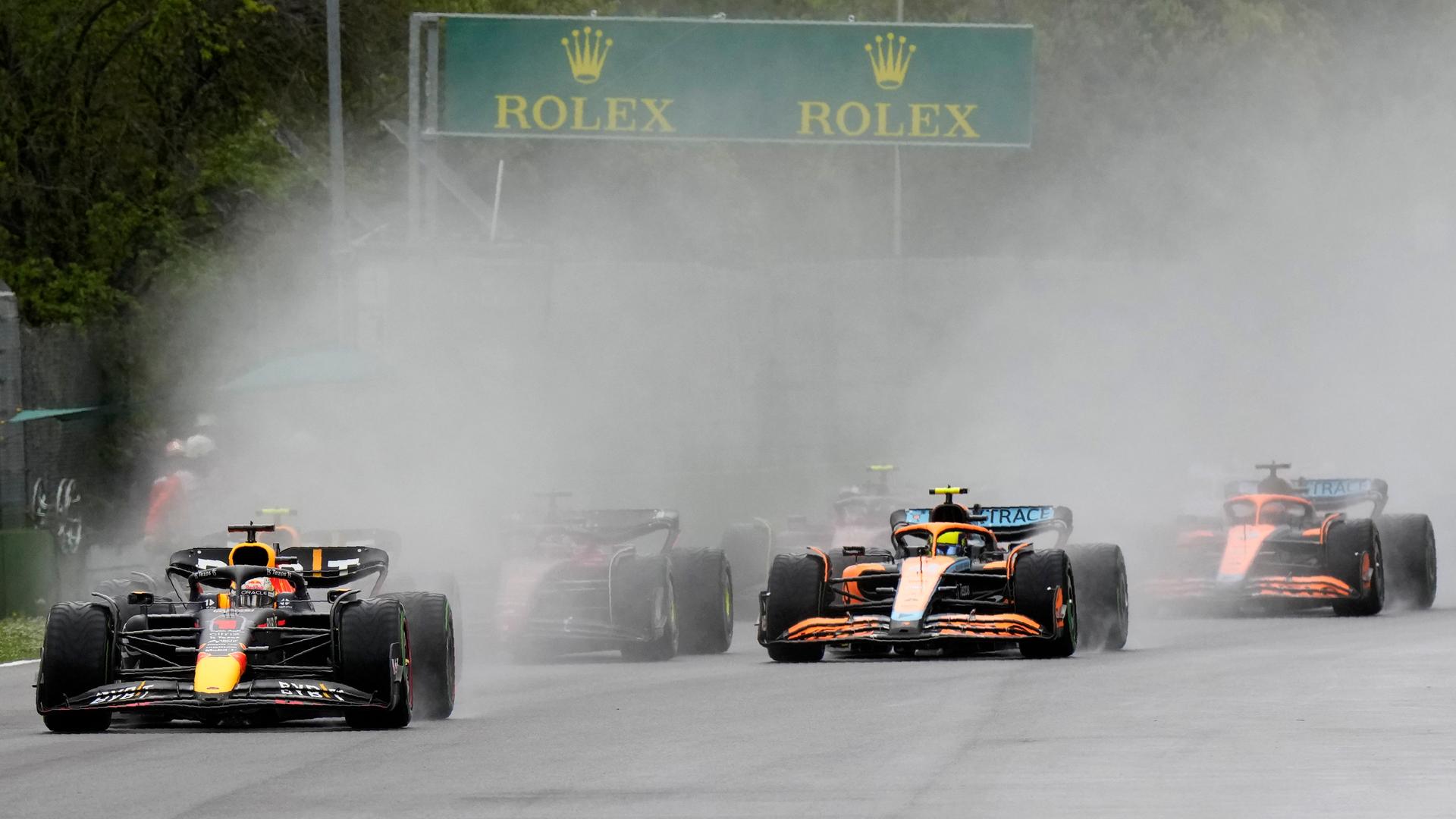 Mehrere Formel 1-Rennwagen fahren beim Großen Preis von Imola in Italien während einer Regenphase.