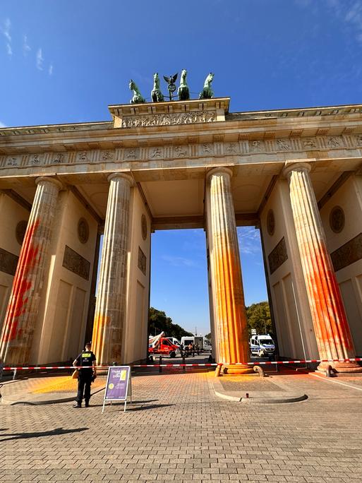 Die Säulen des Brandenburger Tores in Berlin mit Farbe besprüht. Der Bereich vor dem Tor ist abgesperrt. 