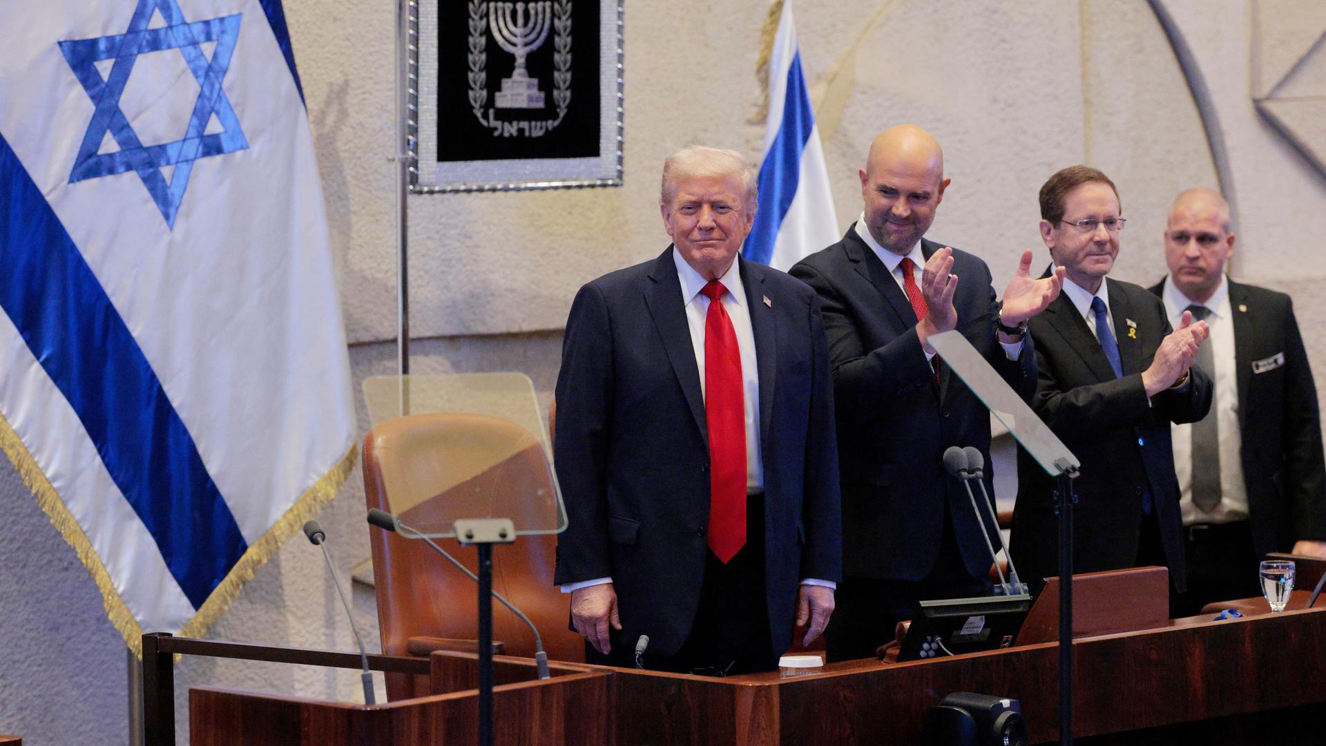 US-Präsident Trump nimmt lächelnd die stehenden Ovationen der Knesset-Mitglieder an.