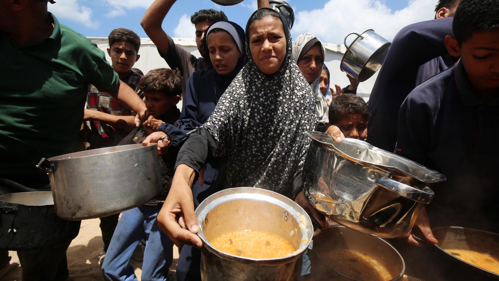 Wohltätigkeitsorganisationen verteilen warme Mahlzeiten an Palästinenser, die aufgrund der israelischen Angriffe auf den Gazastreifen und der geschlossenen Grenzen mit Hunger zu kämpfen haben. Wohltätigkeitsorganisationen verteilen warme Mahlzeiten an Palästinenser, die aufgrund der israelischen Angriffe auf den Gazastreifen und der geschlossenen Grenzen mit Hunger zu kämpfen haben.