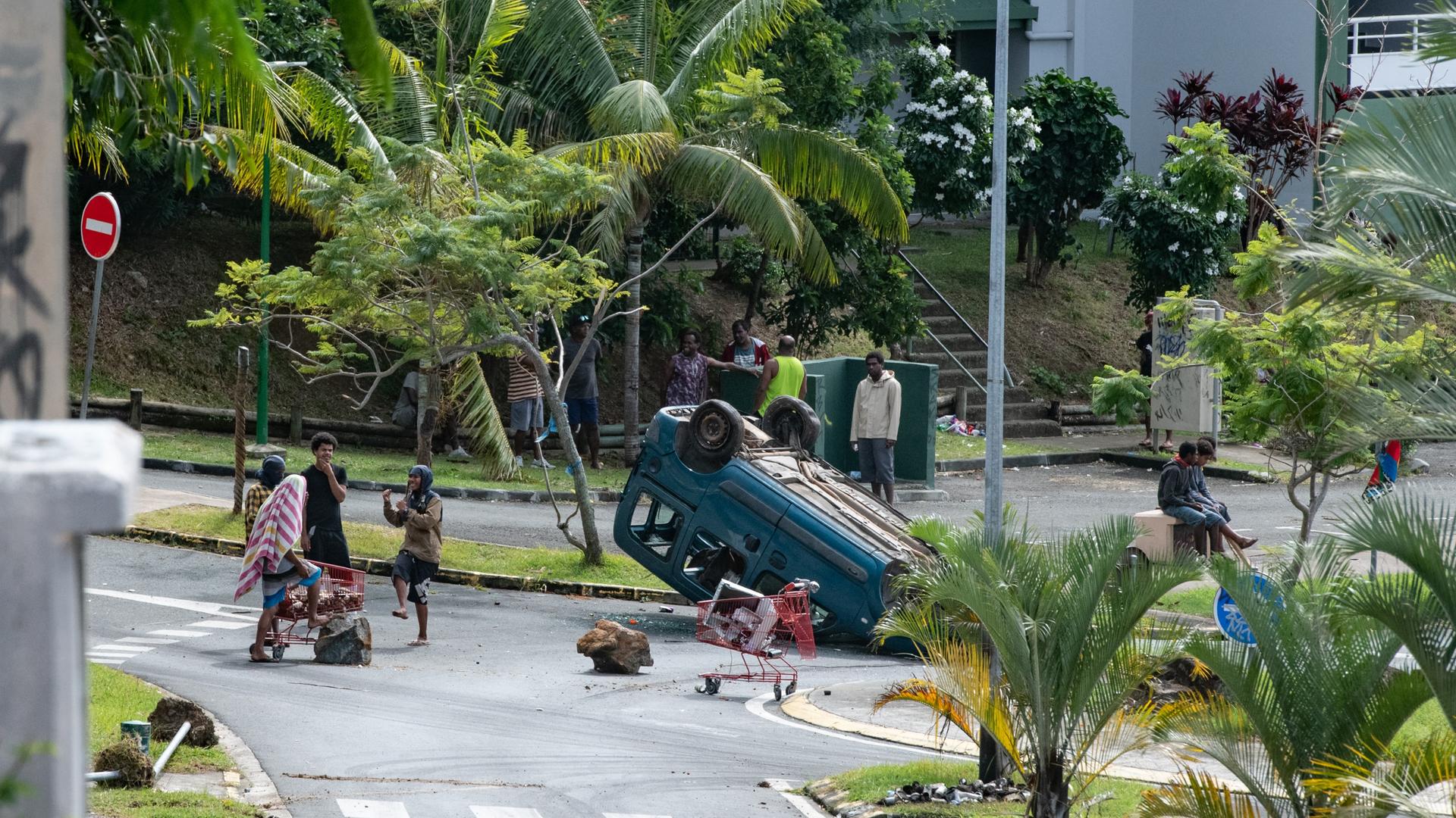 Neukaledonien, Noumea: Menschen stehen um einen umgedrehten Wagen herum. 