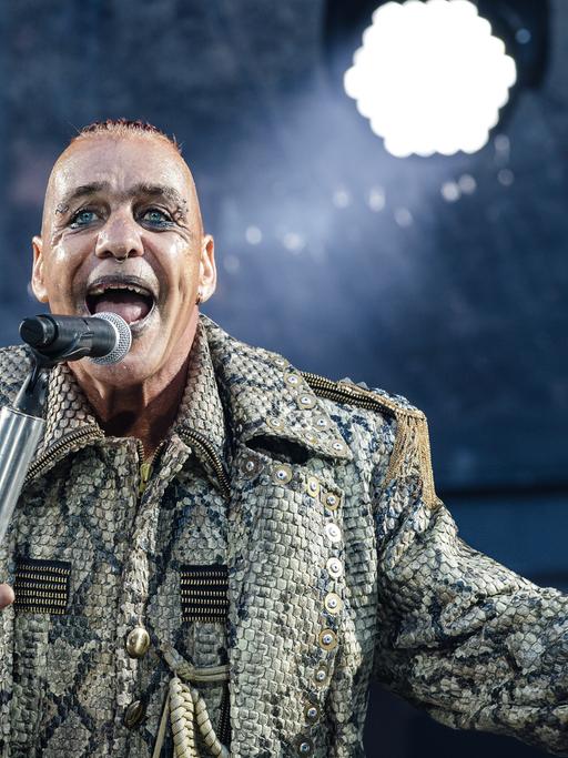 Till Lindemann vor einem Mikrofon auf der Konzertbühne (Juni 2019)