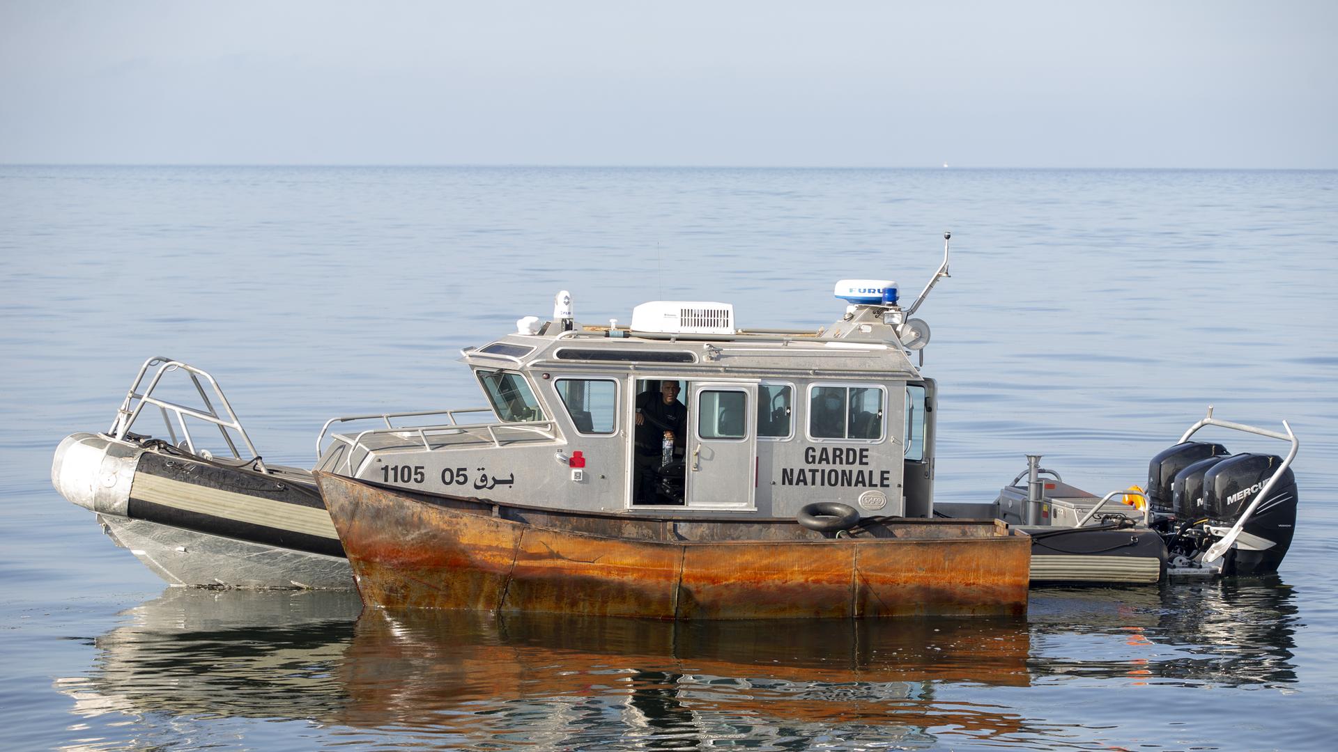 Ein Boot der tunesischen Küstenwache mit einem Boot an der Seite, das von Flüchtlignen zur Überquerung des Mittelmeers genutzt werden sollte.