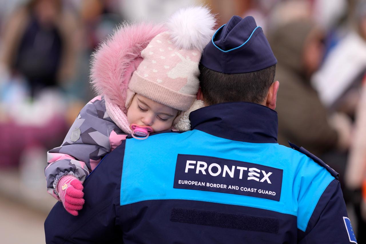 Ein Polizist der Grenzschutzeinheit Frontex trägt ein Kind, das aus der Ukraine an der slowakischen Grenze ankam. 