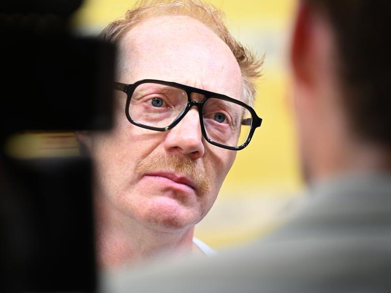 Simon Schwarz mit schwarzer Hornbritte Brille in Nahaufnahme bei der Premiere des Films "Steckerlfischfiasko" 