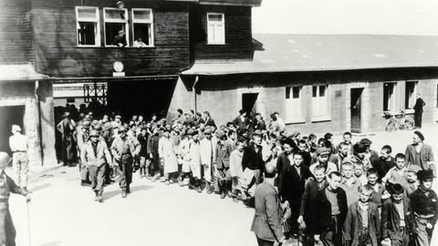 Schwarz-weißes Foto: Menschen verlassen das KZ Buchenwald nach der Befreiung am 11. April 1945.