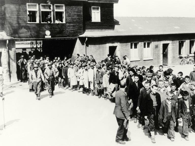 Schwarz-weißes Foto: Menschen verlassen das KZ Buchenwald nach der Befreiung am 11. April 1945.