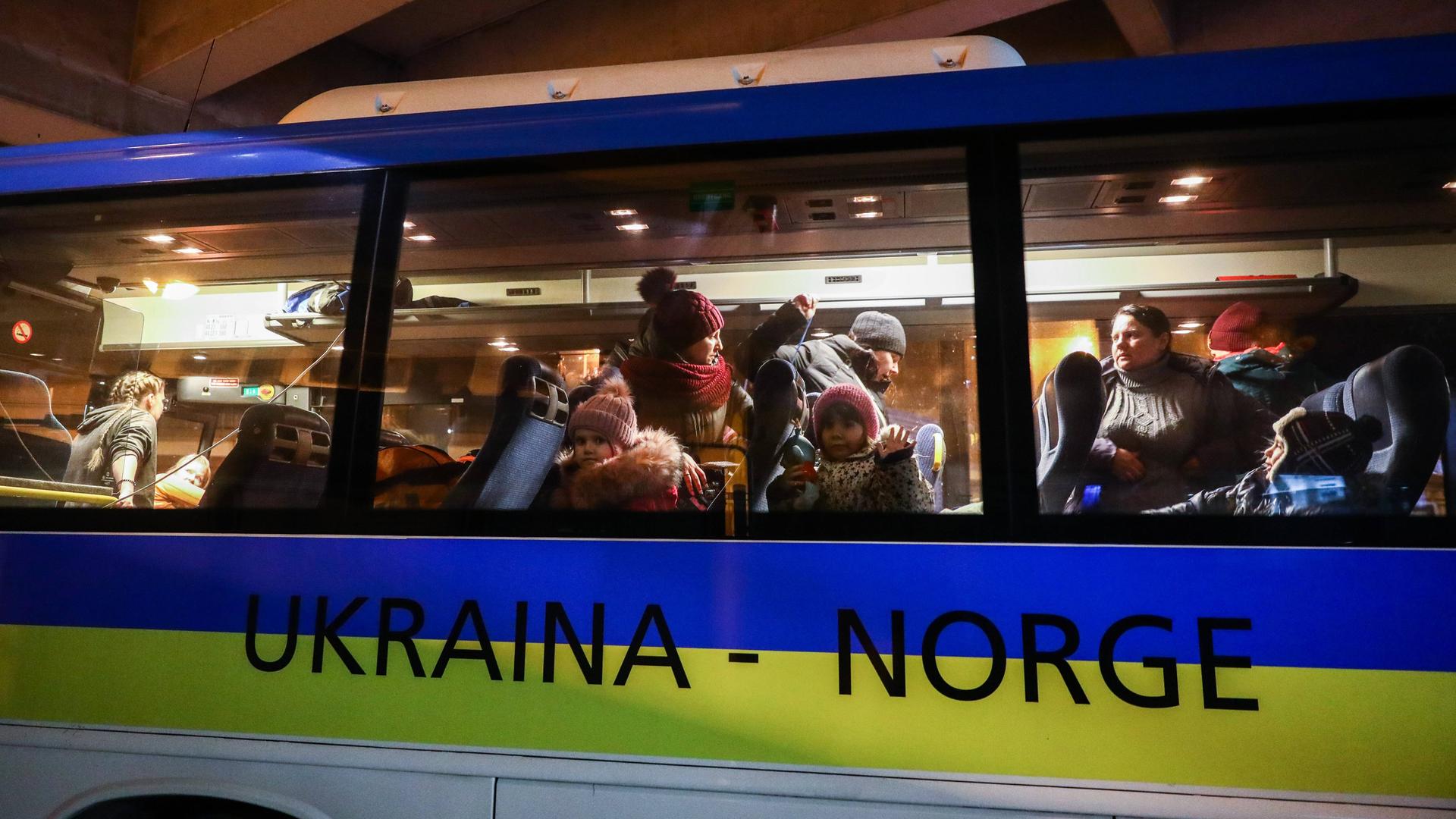 Flüchtlinge aus der Ukraine auf einem Bahnhof in Polen in einem Bus, der nach Norwegen fahren soll.