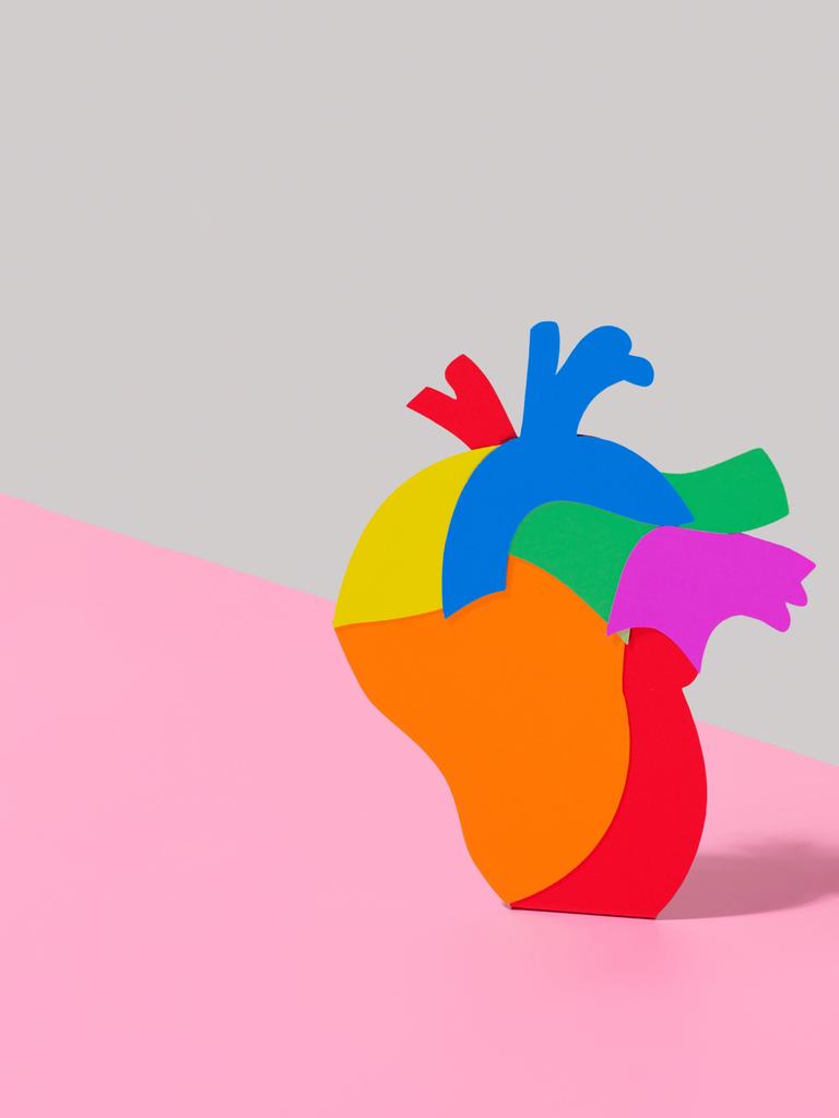 Illustration eines regenbogenfarbenen Herzes vor zweifarbigem Hintergrund.