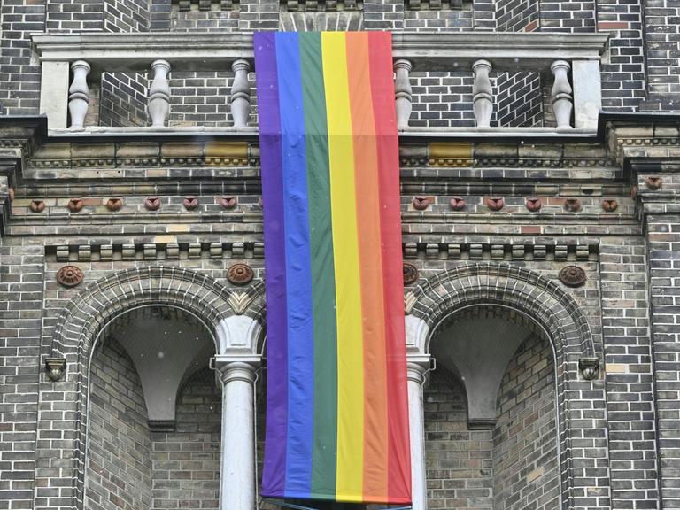 Eine Regenbogenfahne hängt an der Pfarrkirche Breitenfeld in Wien.