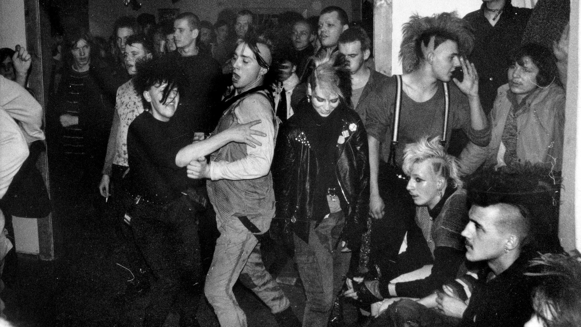Tanzende Punks auf einem Punkkonzert (Schwarzweißaufnahme)