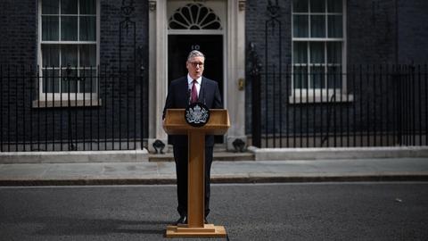 Keir Starmer steht vor der Downing Street no. 10 hinter einem Rednerpult.