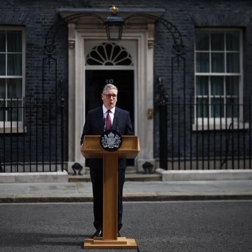 Keir Starmer steht vor der Downing Street no. 10 hinter einem Rednerpult.