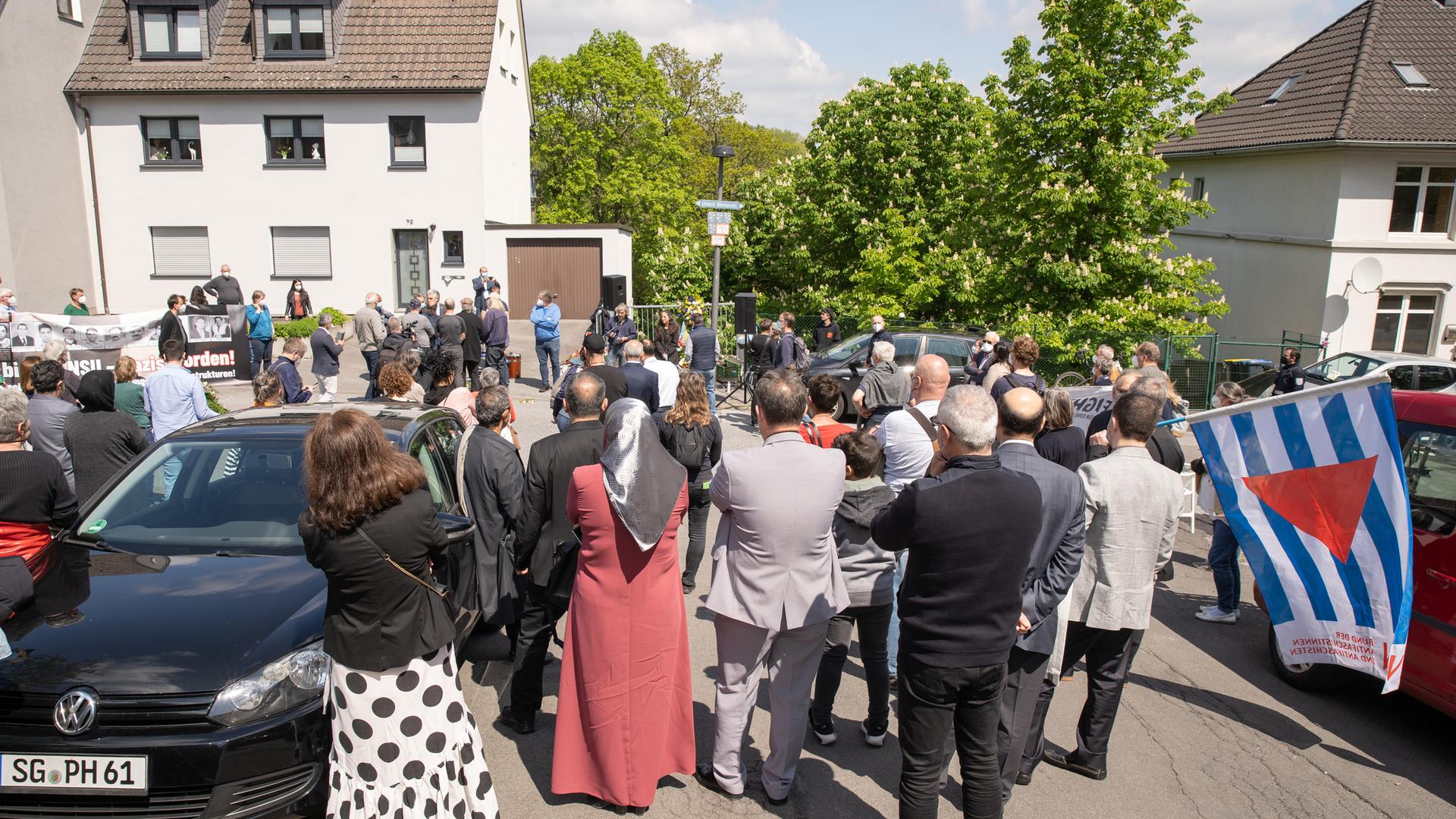Blick von hinten auf die versammelte Menschenmenge, die auf einer Straße vor dem Platz des ehemaligen Hauses steht. Blick von hinten auf die versammelte Menschenmenge, die auf einer Straße vor dem Platz des ehemaligen Hauses steht.
