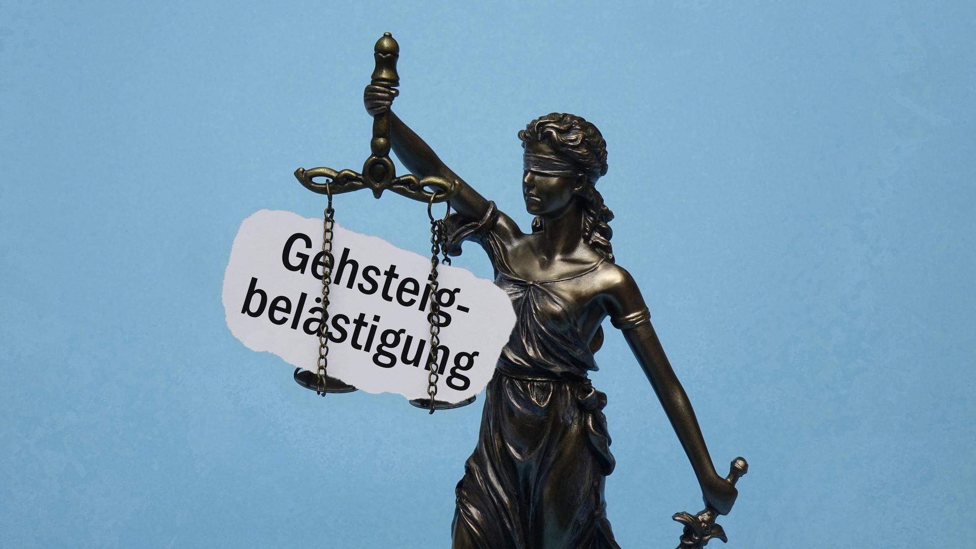 Das Modell der Justitia trägt den Schriftzug Gehsteigbelästigung.