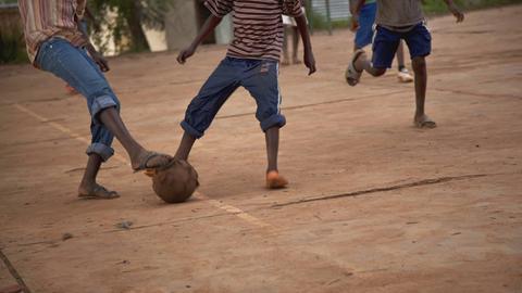 Kinder spielen in Ruanda Fußball auf der Straße.